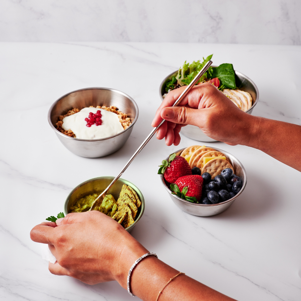14cm stainless steel bowl with round edges, filled with guacamole, surrounded by bowls of yogurt, fruit, and snacks.