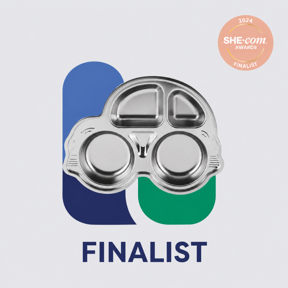 Stainless steel children's divided plate shaped like a car, with two round compartments and two smaller upper sections, displayed on a light grey background. A 2024 SHE-com Awards Finalist badge appears in the top right, with bold text at the bottom reading: "FINALIST."