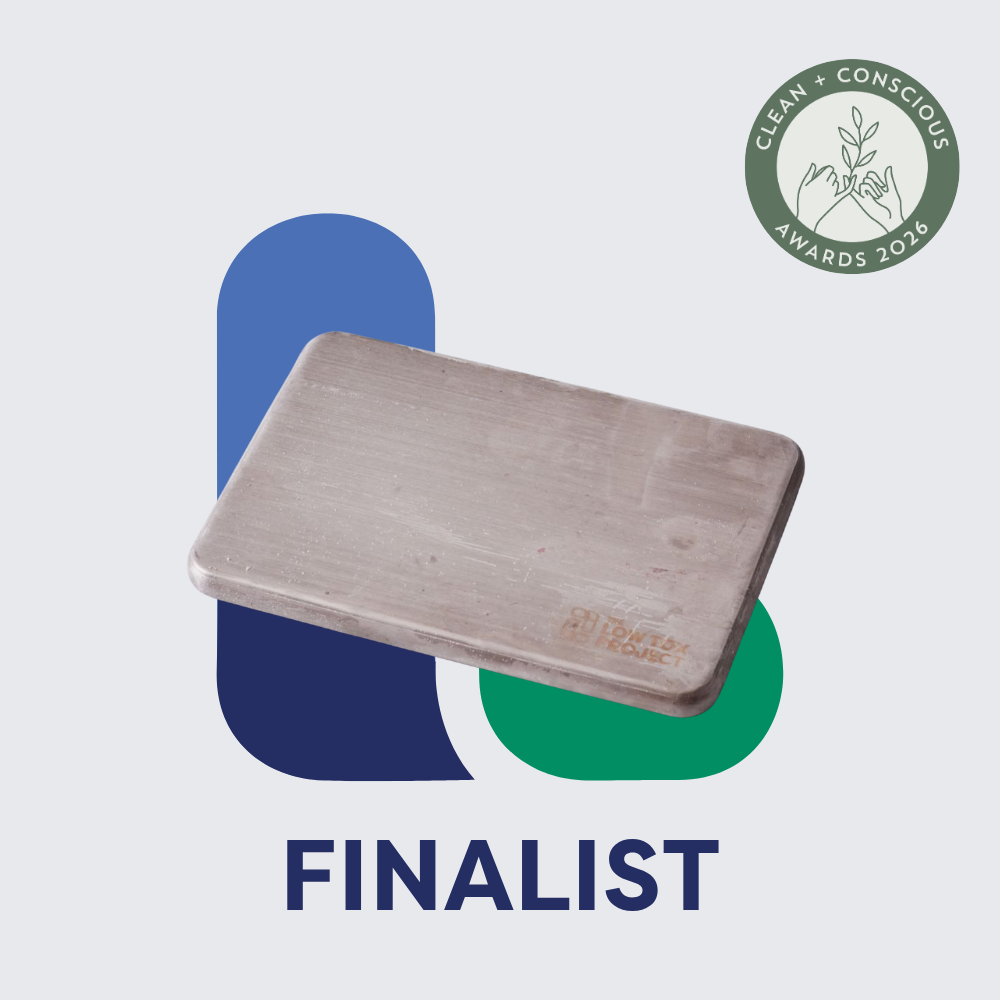 Rectangular stainless ice brick displayed on a clean white background with abstract blue and green shapes. A green "Clean + Conscious Awards 2026" finalist badge appears in the top right, with the word FINALIST in large navy text below.