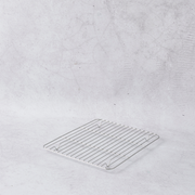 Stainless steel cooling rack in a small square shape with evenly spaced wires, set against a light gray background.
