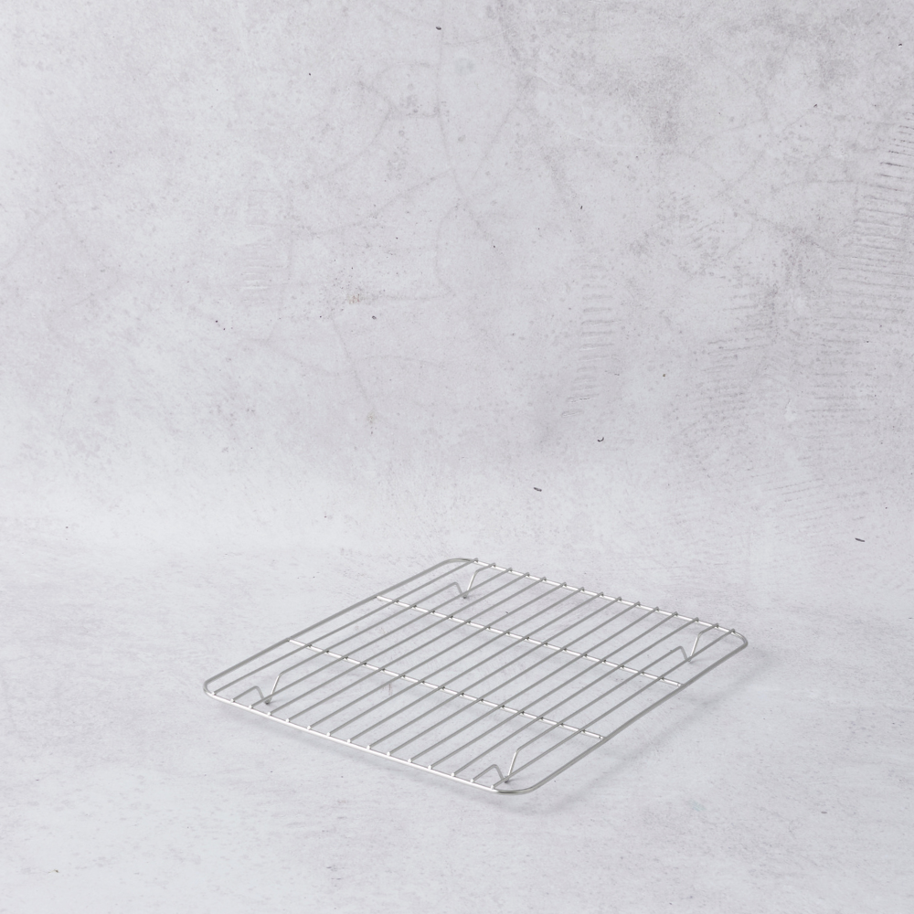 Stainless steel cooling rack in a small square shape with evenly spaced wires, set against a light gray background.