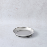 Stainless steel round plate with a suction base, featuring a smooth, reflective surface and a minimalist design.