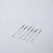 Set of six reusable stainless steel double-prong barbecue skewers with loop handles on a light textured background.